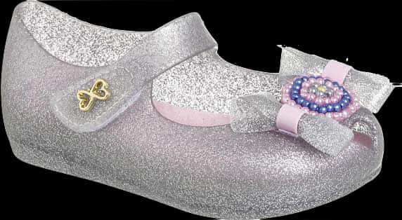 A Silver Glittery Shoe With A Bow And Beads